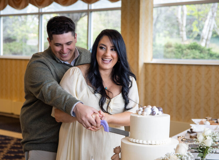 Expecting couple cuts cake at baby shower