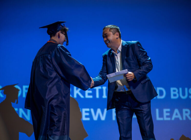 Graduate shakes hands on stage