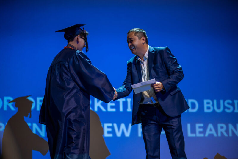Graduate shakes hands on stage