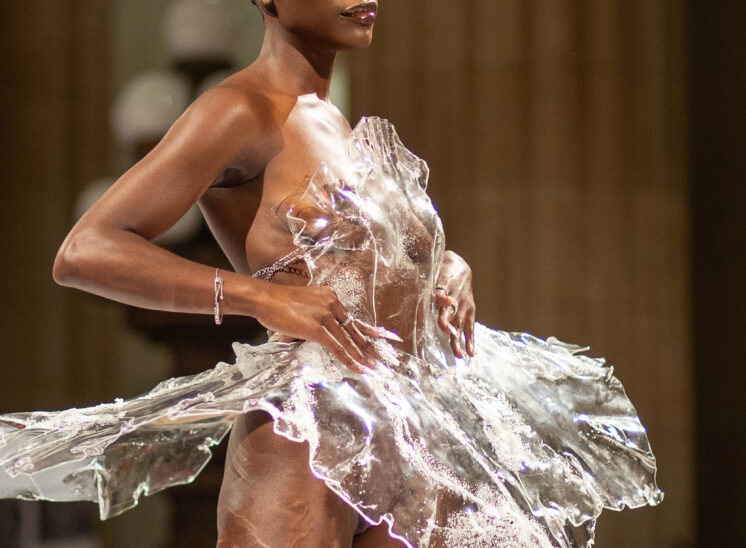 Model in plastic dress stands on runway in Cleveland