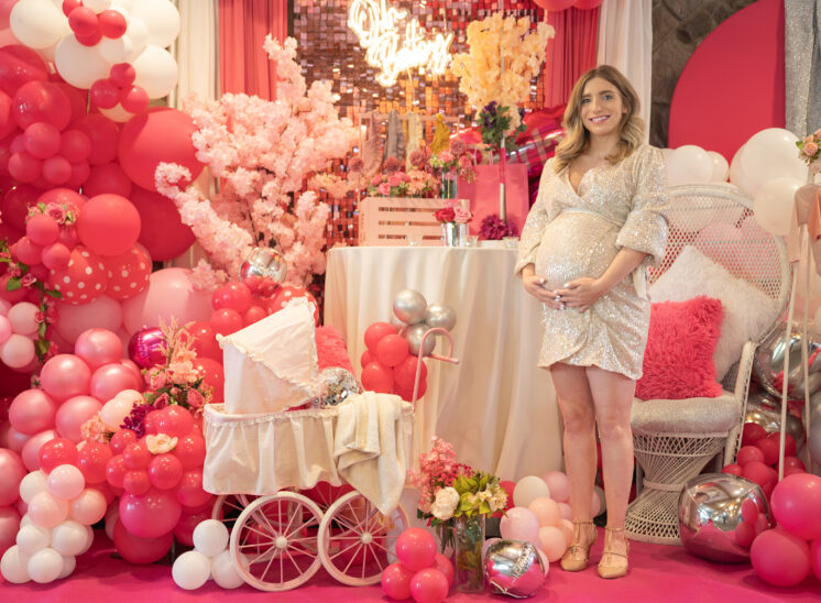 Mom to be sits with baby shower decorations