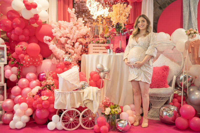 Mom to be sits with baby shower decorations