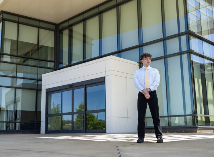 senior poses at modern building