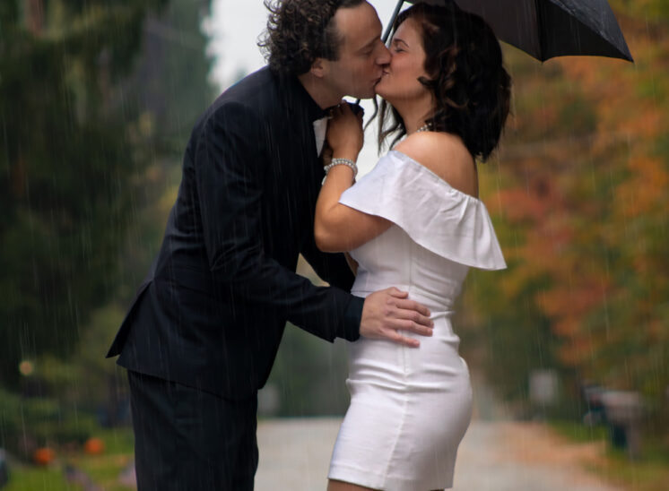 Wedding couple kiss in the rain
