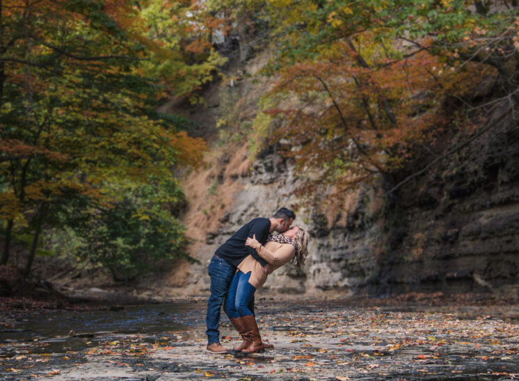 Couple kiss in creek during engagement photos