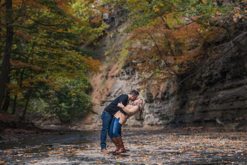 Couple kiss in creek during engagement photos