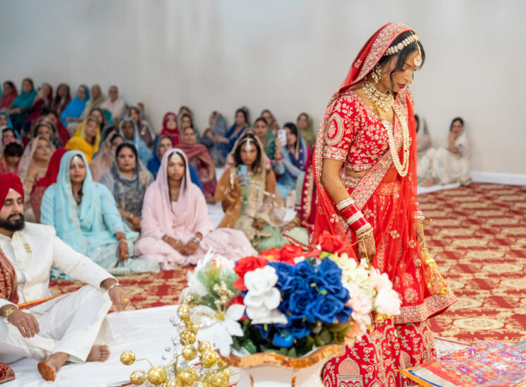 Bride kneels at alter during Indian wedding