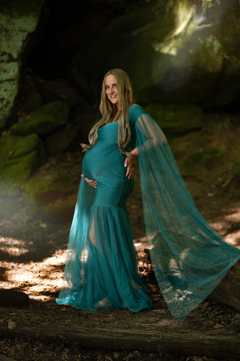 Pregnant woman holds belly during maternity shoot