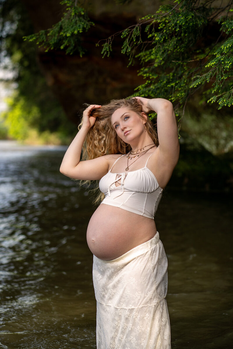 Pregnant model fixes hair during maternity shoot