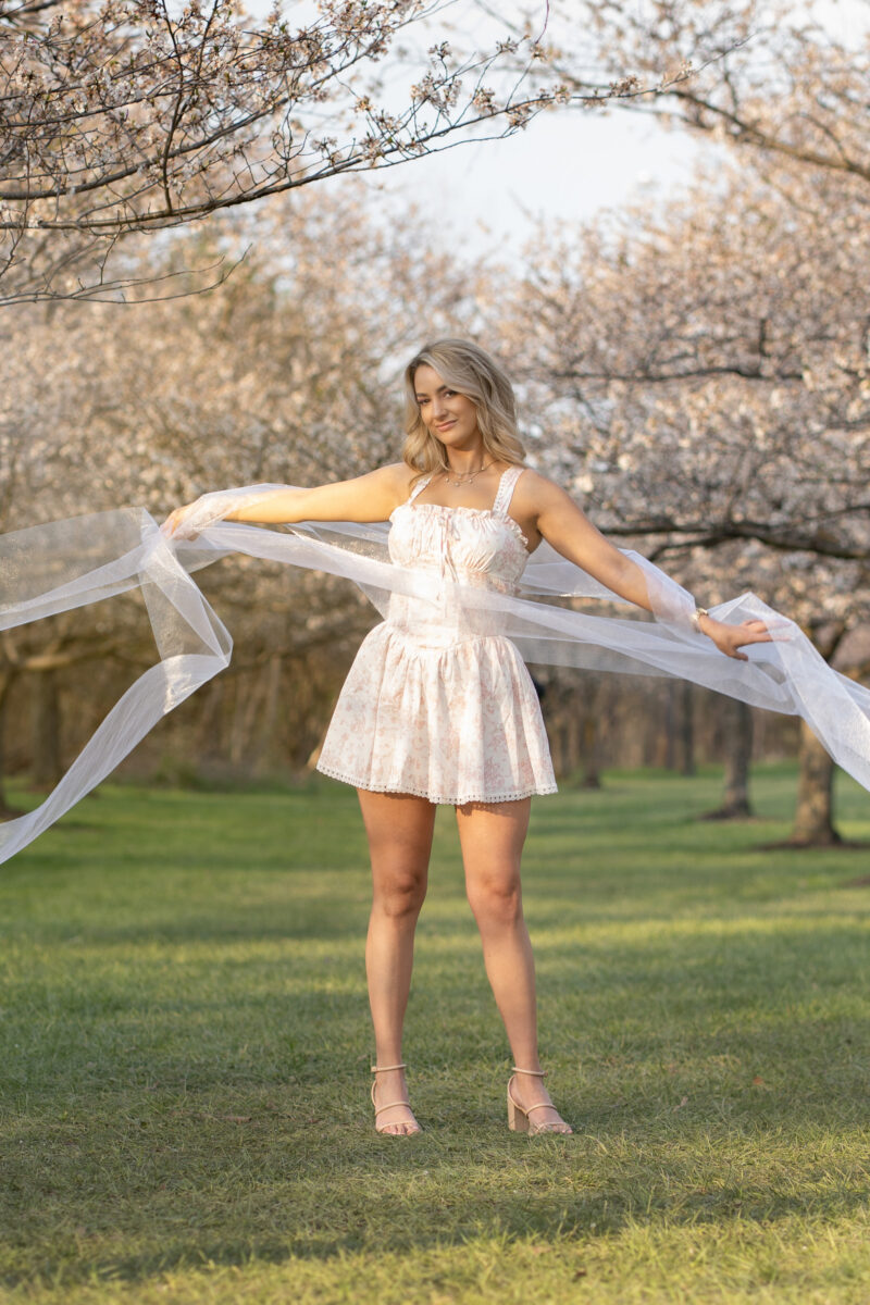 Model poses between Cleveland cherry trees